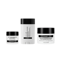 Three skincare products from The Inkey List on a plain white background: a small eye cream jar, a tall cream stick, and a moisturizer jar. The containers are white with black lids and black label bands.